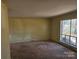 A bright living room with carpet, a large window offering ample natural light, and a neutral color scheme at 1608 Carfax Dr, Charlotte, NC 28216