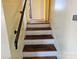 Classic staircase with wooden treads, white risers, and a sturdy handrail at 1608 Carfax Dr, Charlotte, NC 28216