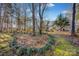 View of the home's backyard with a circular garden, mature trees, and a sunny lawn at 161 Picwyck Dr, Mooresville, NC 28115
