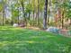 A lush backyard showing a well-manicured lawn with azaleas and mature trees at 161 Picwyck Dr, Mooresville, NC 28115