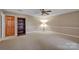 Spacious bonus room with a ceiling fan, wainscoting, and a neutral color palette at 161 Picwyck Dr, Mooresville, NC 28115
