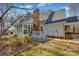 Back of the home with an enclosed porch, brick chimney, covered patio, and beautiful landscaping at 161 Picwyck Dr, Mooresville, NC 28115
