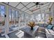 Bright sunroom with vaulted ceilings, skylights, a ceiling fan, and large windows overlooking a treed backyard at 161 Picwyck Dr, Mooresville, NC 28115