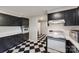 Kitchen with black cabinets, white appliances, and a checkerboard floor at 2209 Kings Dr, Gastonia, NC 28056