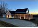 Farmhouse exterior, expansive porch, driveway, and landscaping at 243 Reese Wilson Rd, Belmont, NC 28012