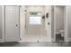 Bathroom with a glass-enclosed shower, window and neutral-colored tiling at 4150 Summit Ridge Ln, Denver, NC 28037