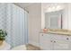 Well-lit bathroom featuring a shower with patterned curtain and a granite-topped vanity with storage at 4150 Summit Ridge Ln, Denver, NC 28037