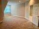 Bedroom features neutral carpet and trim, a window with mini blinds, and a connecting doorway at 4150 Summit Ridge Ln, Denver, NC 28037