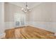 Dining room features hardwood floors, elegant chandelier, and decorative wall paneling at 4150 Summit Ridge Ln, Denver, NC 28037