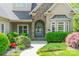 Up close view of the front door, showing stone detail, arched entryway, and manicured landscaping at 4150 Summit Ridge Ln, Denver, NC 28037