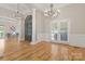 Open concept living room featuring hardwood floors, elegant lighting, and neutral decor at 4150 Summit Ridge Ln, Denver, NC 28037