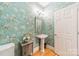 Elegant powder room with pedestal sink, decorative wallpaper, and hardwood floors at 4150 Summit Ridge Ln, Denver, NC 28037