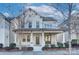 Two-story white brick home with a front porch and landscaping at 8941 Matthews Farm Ln, Charlotte, NC 28277