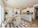 Modern kitchen with island, white cabinets, and glass dining table at 1412 Windy Park Dr, Stanley, NC 28164
