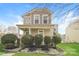 Two-story house with beige siding, front porch, and landscaping at 19054 Long Pond Ln, Cornelius, NC 28031