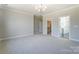 Large bedroom showcasing gray walls, carpet, and access to a walk-in closet and bathroom at 3432 Greene Rd, Monroe, NC 28110