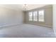 An empty bedroom with gray carpet and large bright windows at 3432 Greene Rd, Monroe, NC 28110