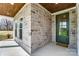 Close-up of the front entrance showing stone facade, a stained wood ceiling, and a view to the yard at 3432 Greene Rd, Monroe, NC 28110