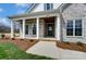 Stunning home entrance with stone accents, white pillars, and a stained wood ceiling on the covered porch at 3432 Greene Rd, Monroe, NC 28110