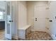 Open mudroom featuring coat rack, bench, and hexagon tile floors at 3432 Greene Rd, Monroe, NC 28110