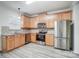 L-shaped kitchen featuring light wood cabinets and stainless steel appliances at 4005 Linville Falls Ln, Monroe, NC 28110