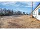 Large backyard with dry grass and a view of the home's exterior at 4109 Pebblebrook Sw Cir, Concord, NC 28027