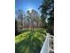 Sunny backyard with expansive lawn, mature trees, and white fence at 118 Sterling Dr, York, SC 29745