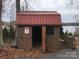 Brown storage shed with red roof, providing extra storage at 119 River Ridge Trl # E175/176, Mount Gilead, NC 27306
