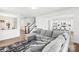 Open-concept living room with large gray sofa, stylish rug, and modern kitchen view at 144 Mooring Dr, Statesville, NC 28677