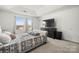 Carpeted primary bedroom features a large window, ceiling fan, and mounted television at 144 Mooring Dr, Statesville, NC 28677