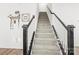 Carpeted staircase with black and white railings leading to the upper level at 144 Mooring Dr, Statesville, NC 28677