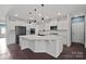 Modern kitchen features white cabinets, large island, and stainless steel appliances at 15725 Queens Trail Dr, Davidson, NC 28036