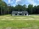 A charming one-story home with a fresh green lawn, complemented by a backdrop of lush trees at 2227 Charlotte Hwy, York, SC 29745