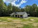 A classic one-story home boasts a lush lawn, complemented by verdant trees and a bright blue sky at 2227 Charlotte Hwy, York, SC 29745