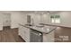Kitchen island with granite countertop, stainless steel dishwasher, and a view of the open floor plan at 2227 Charlotte Hwy, York, SC 29745