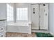 Spa-like bathroom featuring a soaking tub, shower, and large window at 2609 Lamp Post Ln, Kannapolis, NC 28081