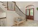 Bright entryway with a wooden bench, featuring a grand staircase and double doors at 3255 Lake Pointe Dr, Belmont, NC 28012