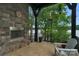 Covered patio with stone fireplace and tranquil lake views at 3255 Lake Pointe Dr, Belmont, NC 28012