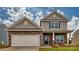 Two-story home with stone and shingle accents, two-car garage, and landscaped yard at 3686 Charles Nw St, Conover, NC 28613