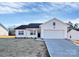 White house with a two-car garage and a neatly landscaped yard at 4115 Pebblebrook Sw Cir, Concord, NC 28027