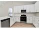 Modern kitchen with white cabinets, stainless steel appliances, and quartz counters at 4119 Pebblebrook Sw Cir, Concord, NC 28027