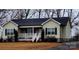 Tan house with white trim, a front porch, and a landscaped yard at 4921 Cr Wood Rd, Gastonia, NC 28056