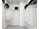 Spacious walk-in closet with white wire shelving, garment bags and black storage boxes on upper shelves at 5715 Castlerea Dr, Charlotte, NC 28217