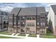 Three-story townhouses with gray siding and brick accents at 6028 Fonsac Ln # 2005C, Charlotte, NC 28217