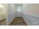 Entryway with hardwood floors, white wainscoting, and access to bathroom at 6806 Harris Bay Rd, Charlotte, NC 28269