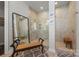 Bright bathroom with glass enclosed shower and bench, tile surround, and detailed mirror at 7150 Irongate Dr, Indian Land, SC 29707