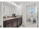Bathroom features double sinks with dark wood cabinets, granite countertop and marble tile floor at 7150 Irongate Dr, Indian Land, SC 29707