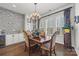 Elegant dining room with dark wood floors, decorative chandelier, and bright, shuttered windows at 7150 Irongate Dr, Indian Land, SC 29707