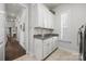 Bright laundry room with white cabinets, granite countertop, sink, window, and tile flooring at 7150 Irongate Dr, Indian Land, SC 29707