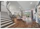 Open-concept living room with hardwood floors, staircase, fireplace, and views of the kitchen and backyard at 7150 Irongate Dr, Indian Land, SC 29707